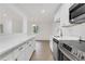 Bright kitchen features white cabinetry, stainless steel appliances, stone countertops, and gold hardware at 2396 Lawrenceville Hwy # V, Decatur, GA 30033