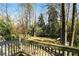 An outside elevated wooden deck overlooks a grassy backyard surrounded by mature trees at 6275 Hunting Creek Rd, Atlanta, GA 30328