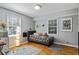 Well-lit bedroom with hardwood floors, neutral gray walls, and two windows with natural sunlight at 6275 Hunting Creek Rd, Atlanta, GA 30328
