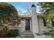 Charming home featuring a black front door, painted brick, stone steps, and mature landscaping at 6275 Hunting Creek Rd, Atlanta, GA 30328