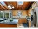 Bright kitchen with wood ceilings, stainless steel appliances, island, and a view of the backyard at 6275 Hunting Creek Rd, Atlanta, GA 30328