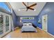 Bright main bedroom features a ceiling fan, blue walls, light wood floors, and a glass door to the outside at 6275 Hunting Creek Rd, Atlanta, GA 30328
