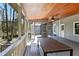 Inviting screened porch featuring a wooden ceiling, dining table, and peaceful view of the surrounding greenery at 6275 Hunting Creek Rd, Atlanta, GA 30328