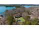 Stunning aerial view of a beautiful home nestled amongst lush trees with lake views in the distance at 7565 Heard Rd, Cumming, GA 30041
