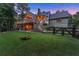 Beautifully landscaped backyard with string lights, large deck, fenced perimeter, and plenty of room for outdoor games at 7565 Heard Rd, Cumming, GA 30041