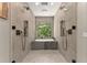 Luxurious bathroom featuring a soaking tub, a walk-in shower, and a view of the outdoors at 7565 Heard Rd, Cumming, GA 30041