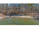 Beach view featuring a sandy area, clear water, and a wooded shoreline, with a small boat on the water at 7565 Heard Rd, Cumming, GA 30041