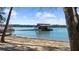 Beach view featuring a boat dock with upper level and stairs, with a small boat on the sandy beach at 7565 Heard Rd, Cumming, GA 30041