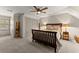 Cozy bedroom features neutral colors, a large bed, a ceiling fan and natural light at 7565 Heard Rd, Cumming, GA 30041
