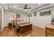Bedroom featuring hardwood floors, four-poster bed, tray ceiling, and neutral paint at 7565 Heard Rd, Cumming, GA 30041