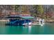 View of boat dock featuring multiple boat slips and a sundeck on top, situated on a serene body of water at 7565 Heard Rd, Cumming, GA 30041