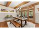 Dining room with a wooden table and bench seating, wood beams, and access to the screened-in porch at 7565 Heard Rd, Cumming, GA 30041