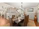 Formal dining room with elegant wainscoting, a decorative chandelier, and seating for eight at the table at 7565 Heard Rd, Cumming, GA 30041