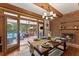 Cozy dining area with a fireplace, wooden table, bench seating, and access to screened porch at 7565 Heard Rd, Cumming, GA 30041