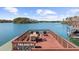 Dock deck with dining table and lounge seating overlooking the serene lake and surrounding islands at 7565 Heard Rd, Cumming, GA 30041