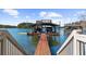 View of a boat dock with boat slips and upper deck with a wooden walkway and railing leading to the dock at 7565 Heard Rd, Cumming, GA 30041