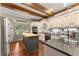 Charming kitchen featuring an island, granite countertops, stainless steel appliances, and wood beam ceilings at 7565 Heard Rd, Cumming, GA 30041
