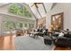 Bright living room with hardwood floors, soaring windows, vaulted ceiling, and leather furniture at 7565 Heard Rd, Cumming, GA 30041