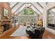 Bright living room with a fireplace, hardwood floors, cathedral ceiling, and large windows at 7565 Heard Rd, Cumming, GA 30041