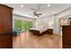 Bright main bedroom boasts hardwood floors, a ceiling fan, and large windows with a view of the trees at 7565 Heard Rd, Cumming, GA 30041