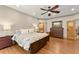 Comfortable bedroom featuring hardwood floors, a ceiling fan, and a decorative furniture piece at 7565 Heard Rd, Cumming, GA 30041