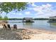Relaxing sandy beach area by the lake, complete with chairs and shaded spots at 7565 Heard Rd, Cumming, GA 30041
