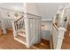 Elegant staircase featuring wood floors and white trim at 7565 Heard Rd, Cumming, GA 30041