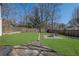 A large, grassy backyard with a stone patio and a fire pit area, enclosed by a wooden fence at 1630 Sylvan Sw Rd, Atlanta, GA 30310