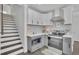 Well-designed kitchen with white cabinets, stainless steel appliances, and adjacent staircase at 1630 Sylvan Sw Rd, Atlanta, GA 30310