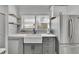 Charming kitchen featuring a farmhouse sink, stainless steel appliances, and floating wood shelves at 1630 Sylvan Sw Rd, Atlanta, GA 30310