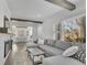 Inviting living room featuring wood beams, a plush gray sectional sofa, and a cozy fireplace at 1630 Sylvan Sw Rd, Atlanta, GA 30310
