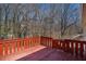 This vibrant red back deck offers an inviting outdoor space, framed by a backdrop of serene trees at 542 Oak Hills Sw Rd, Mableton, GA 30126