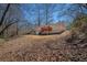 Back exterior view features a red deck and ample backyard space with mature trees surrounding the home at 542 Oak Hills Sw Rd, Mableton, GA 30126