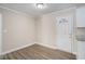 Bright dining room with wood-look flooring, crown molding, and white door to the exterior at 542 Oak Hills Sw Rd, Mableton, GA 30126