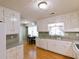 A spacious kitchen with white cabinets, stainless steel appliances, and a dining area at 566 Sugar Valley Lane, Conyers, GA 30094