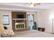 Cozy living room with brick fireplace, a ceiling fan and large windows at 566 Sugar Valley Lane, Conyers, GA 30094