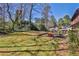 Expansive backyard with lush lawn, stone patio, grilling station, and natural border plants at 571 Tahoe Cir, Stone Mountain, GA 30083