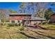 A brick and wood sided house with a stone patio in the backyard with a grill and seating at 571 Tahoe Cir, Stone Mountain, GA 30083