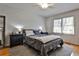 Bedroom with hardwood floors, a rug, large window, and comfortable queen-sized bed and nightstands at 571 Tahoe Cir, Stone Mountain, GA 30083