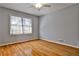 Empty bedroom featuring hardwood floors, a ceiling fan, and a large window providing natural light at 571 Tahoe Cir, Stone Mountain, GA 30083