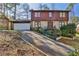Traditional brick and wood home with two-car garage, manicured landscaping, and a long drive way at 571 Tahoe Cir, Stone Mountain, GA 30083