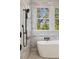 Elegant bathroom featuring a freestanding tub with marble tile and a window view at 818 Springdale Ne Rd, Atlanta, GA 30306