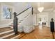 Elegant foyer with hardwood floors, staircase, and a stylish chaise lounge, creating a grand entrance at 818 Springdale Ne Rd, Atlanta, GA 30306