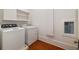 Laundry room with washer, dryer, and cabinets, featuring hardwood floors at 818 Springdale Ne Rd, Atlanta, GA 30306