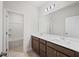 Bright bathroom featuring a double sink vanity with a large mirror and a bathtub in the background at 1246 Allspice Way, Lawrenceville, GA 30045