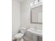 Half bathroom with a pedestal sink, modern mirror, and lighting fixture at 1246 Allspice Way, Lawrenceville, GA 30045