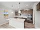 Beautiful kitchen boasts an island, stylish pendant lights, and stainless steel appliances at 1246 Allspice Way, Lawrenceville, GA 30045