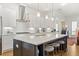 Modern kitchen boasts a large island with seating, stylish pendant lighting, and white cabinetry with stainless appliances at 260 Hemphill Ln, Marietta, GA 30064