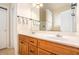 Bathroom featuring a long mirror, wooden cabinets, and modern light fixture at 8000 Abington Dr, Locust Grove, GA 30248