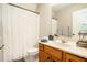 Bathroom features a white shower curtain, wood cabinets, and large mirror at 8000 Abington Dr, Locust Grove, GA 30248